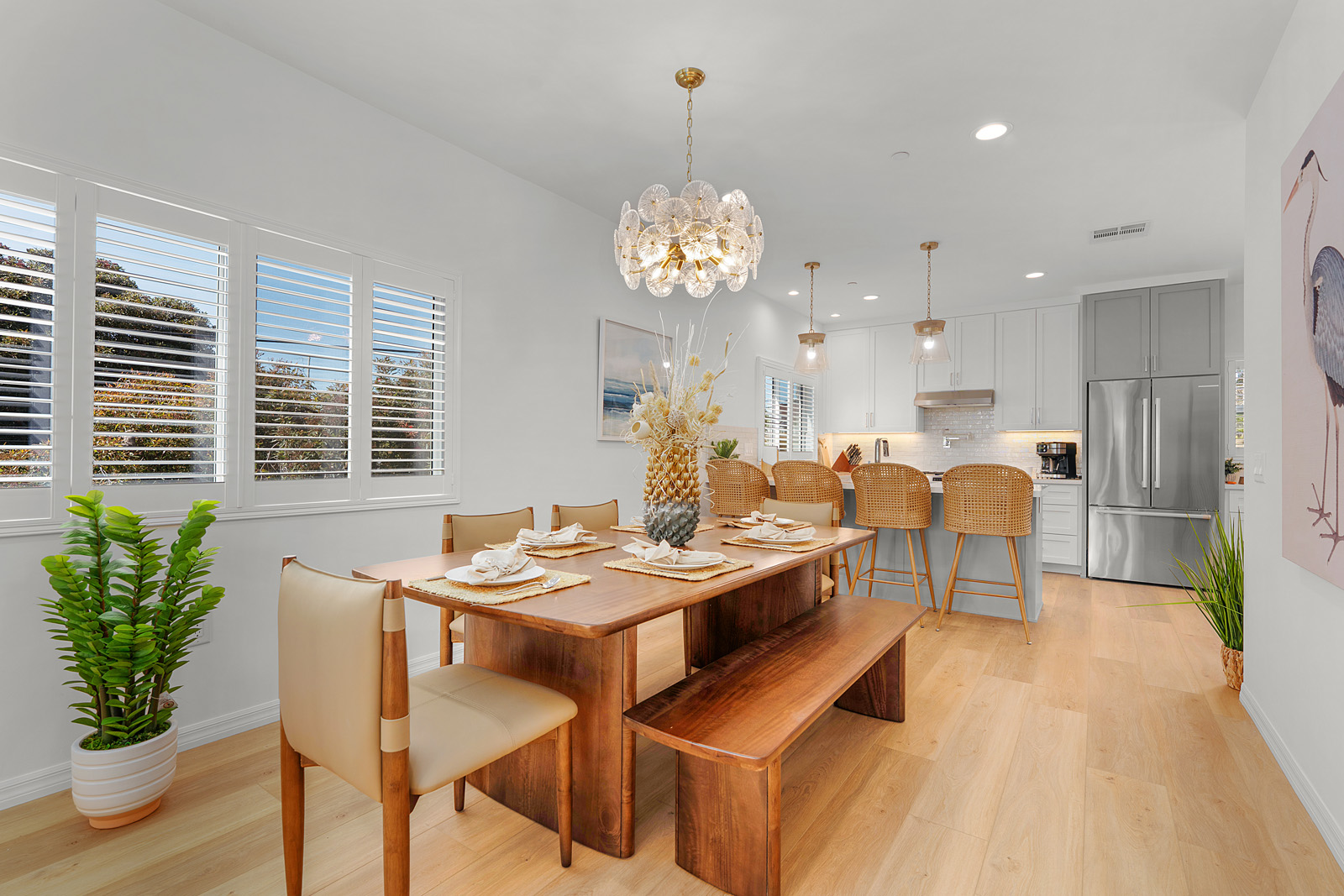 Open-concept dining room adjacent to the kitchen and living area with contemporary finishes in a luxury multifamily residence.